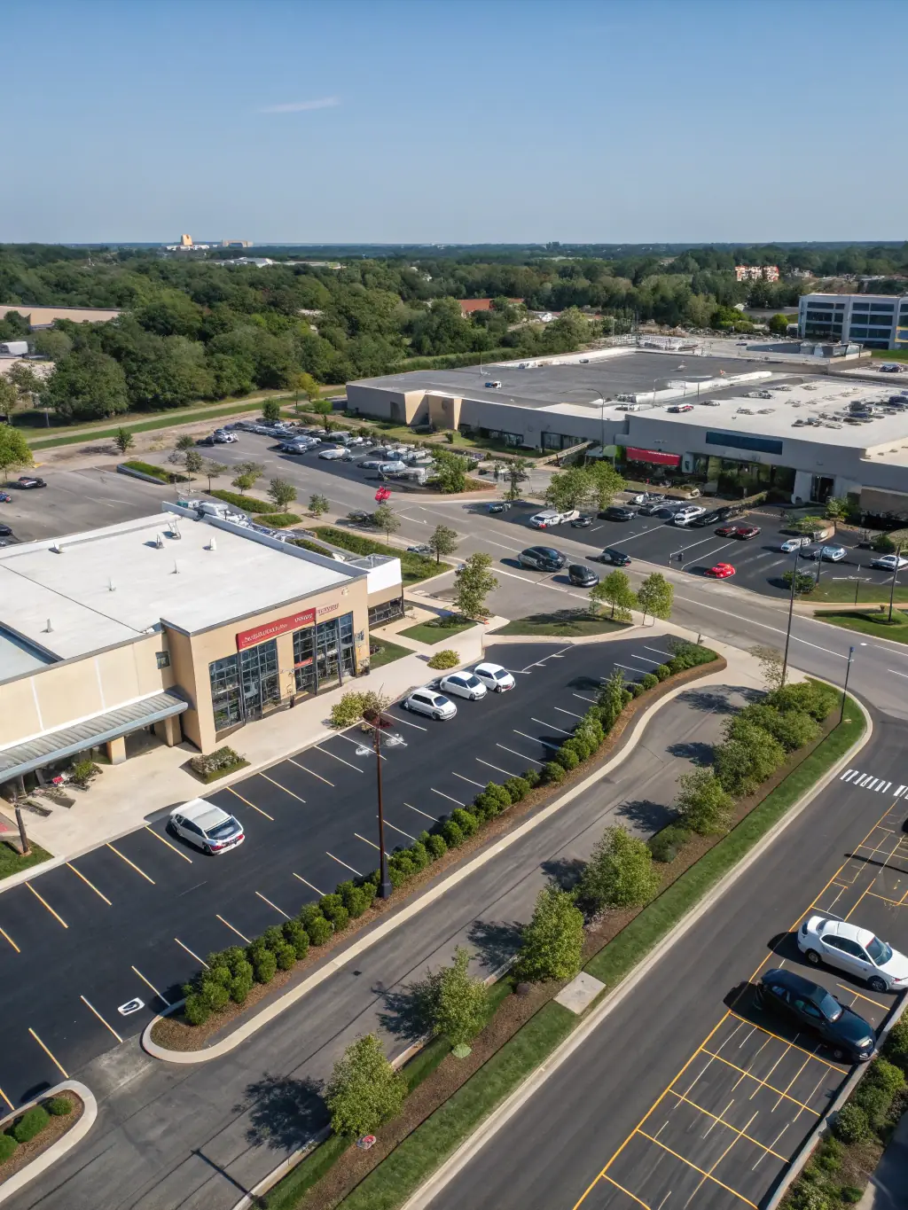 A commercial parking lot meticulously cleaned by Litter Ghost LLC, showcasing a pristine surface free of any litter or debris, with well-maintained landscaping in the background.